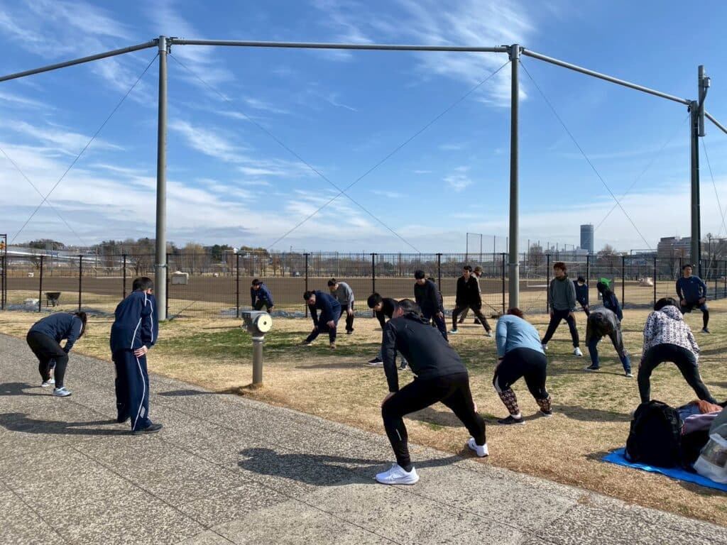 青空の下で準備体操をしている。