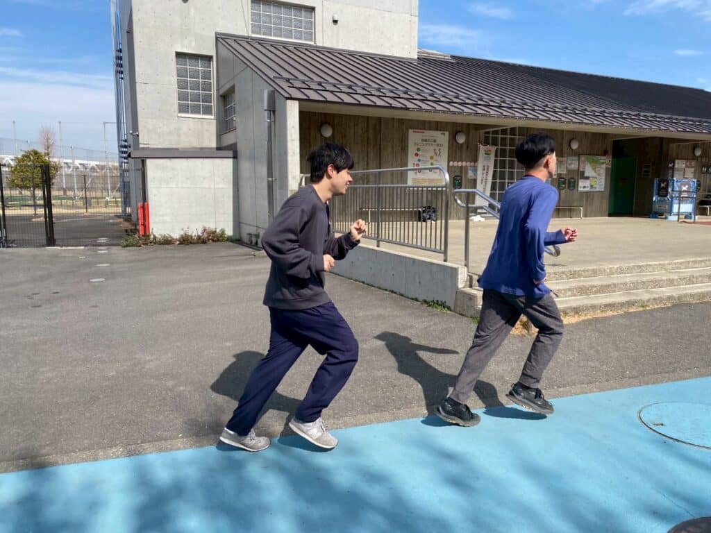 青いラインのマラソンコースを走っている後ろ姿。