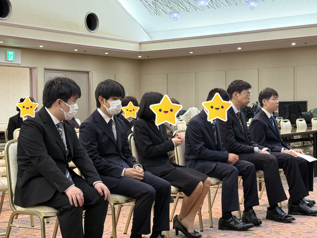 新入生が一列に並んで座っています。