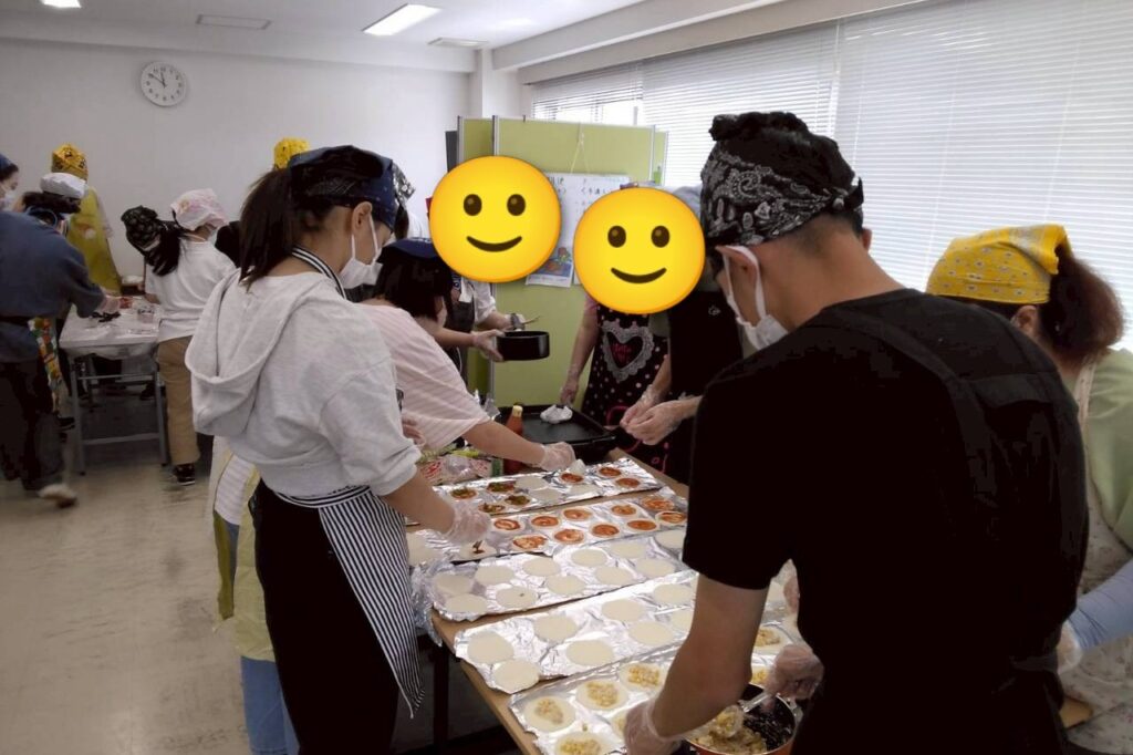 4人くらいで餃子の皮にツナコーンやソーセージを乗せている。