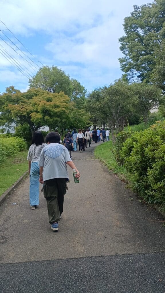 公園の中を一列で歩いている写真。